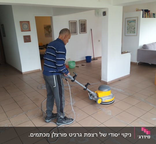 אדם מנקה רצפה עם מכונת פוליש בחדר